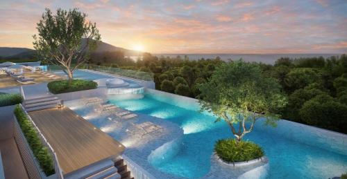a swimming pool with a sunset in the background at C111 Modern 2BR Escape, Steps to Beach & Cafes in Nai Yang Beach
