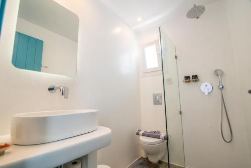 a white bathroom with a sink and a shower at Depis private villas Plaka Naxos in Plaka