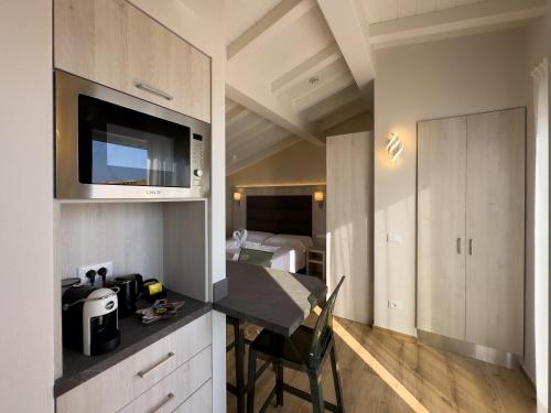 a kitchen with a table and a room with a bed at Junior Suite Hotel Biagi in Lido di Camaiore