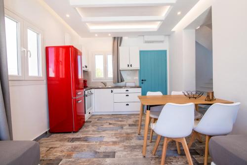 a kitchen with a red refrigerator and a table at Depis private villas Plaka Naxos in Plaka