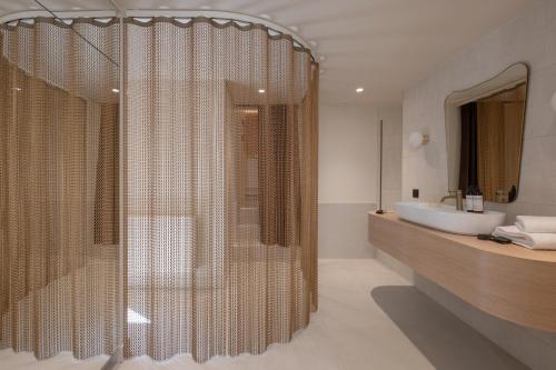 a bathroom with a shower and a white sink at MiHotel Le Gourguillon in Lyon