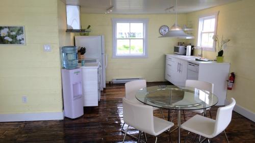 een keuken met een glazen tafel en witte apparaten bij The Old Salt Box Co. - Aunt Christi's in Greenspond