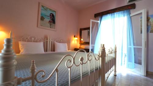 een slaapkamer met een wit bed en een raam bij Antigoni Apartments in Parga