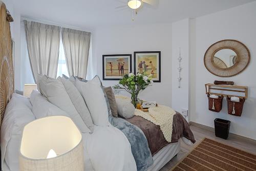 a living room with a white couch and a bed at Boutique Apartment Bloubergstrand Beachfront The Bay in Bloubergstrand