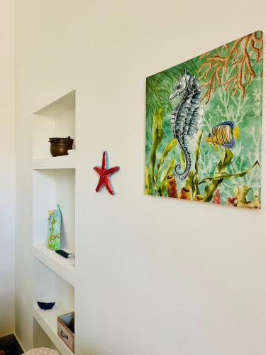 a painting of a seahorse hanging on a wall at Salento apartment in Torre Lapillo