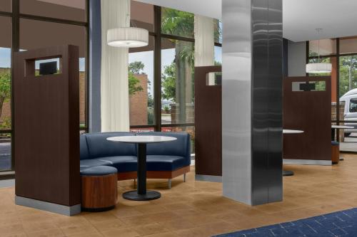 a lobby with a blue chair and a table at Courtyard By Marriott Houston Kingwood in Kingwood