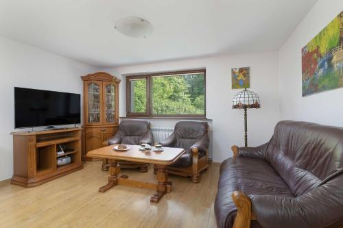 un soggiorno con un divano, un tavolo e una TV di Bystra Unique House in the Mountains with Terrace, Garden & Parking by Noclegi Renters a Bystra