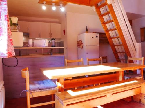 une cuisine avec une table en bois et une échelle dans l'établissement Appartement Montchavin, 2 pièces + mezzanine, 7 pers, pied commerces/pistes, terrasse exposée sud - FR-1-329-70, à La Plagne Tarentaise