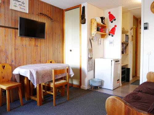 un salon avec une table et un réfrigérateur dans l'établissement Studio rénové Montchavin proche commerces, pistes, avec balcon - FR-1-329-64, à La Plagne Tarentaise