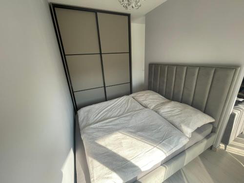 a bed with white sheets and a metal headboard at Meder Apartment in Budapest