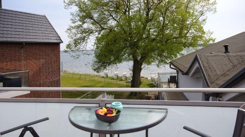 a table on a balcony with a bowl of candy at Haus Seeblick mit 9 Wohnungen in Alt Reddevitz