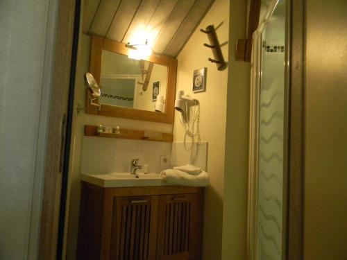 a small bathroom with a sink and a mirror at Logis Relais Des Caillères in Saint Pavace