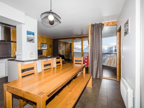 une cuisine et une salle à manger avec une table en bois dans l'établissement Appartement récent 4 pièces, 2 terrasses, parking couvert, pied des pistes - FR-1-329-72, à La Plagne Tarentaise
