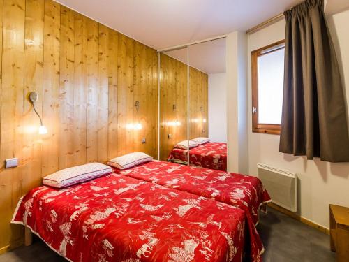- une chambre avec un lit rouge et une fenêtre dans l'établissement Appartement récent 4 pièces, 2 terrasses, parking couvert, pied des pistes - FR-1-329-72, à La Plagne Tarentaise