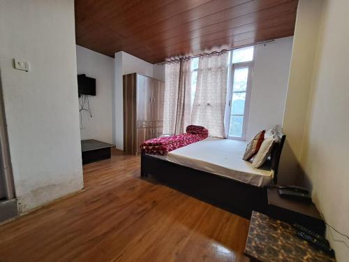 a bedroom with a large bed with a window at Wonder Hill in Nārkanda
