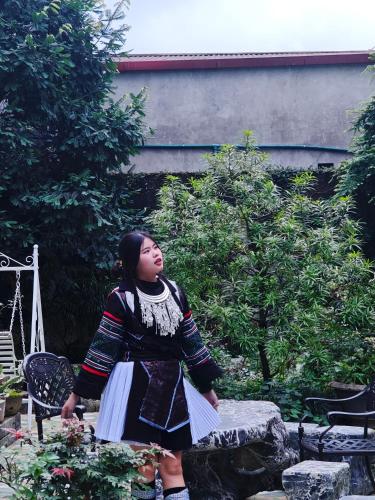 a woman is standing in a garden at SAPA HUB hostel in Sa Pa