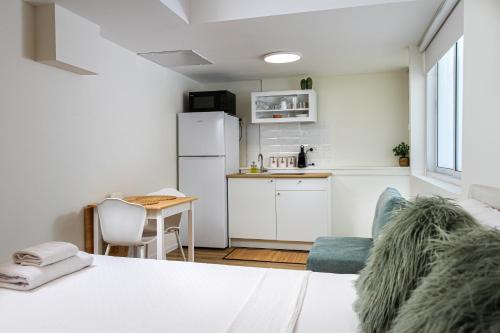 a room with a bed and a kitchen with a refrigerator at Ono Villa at Kiryat Ono in Qiryat Ono