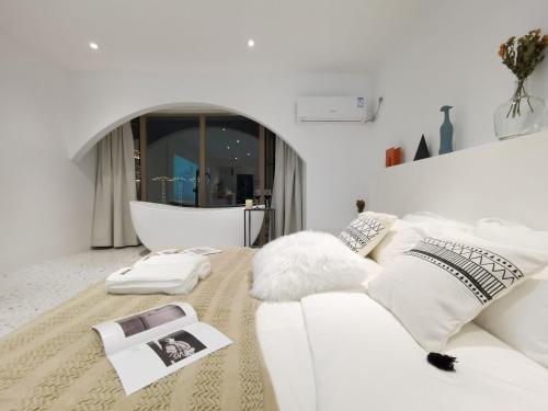 a white living room with a white couch and pillows at Xiaolu Chain Luxury Designer Homestay in Guiyang