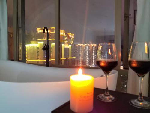 a candle and wine glasses on a table with a window at Xiaolu Chain Luxury Designer Homestay in Guiyang