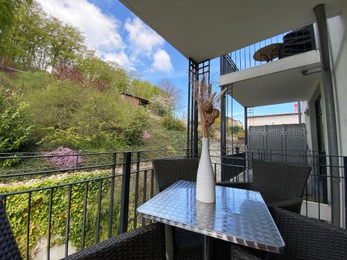 Villa Lena - Whg 09 mit Balkon في اوستيباد سيلين: وجود مزهرية على طاولة على شرفة