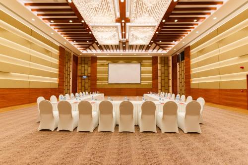 a conference room with a table and chairs and a screen at Ocean's Creek Beach Hotel in Balaclava