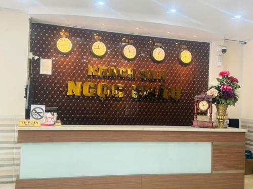 a reception counter with clocks on a wall at Ngọc Châu Hotel Hồ Chí Minh in Ho Chi Minh City