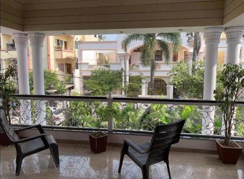 two chairs on a balcony with a view of a building at Ojas Luxury and Peaceful Hotel in Manāli