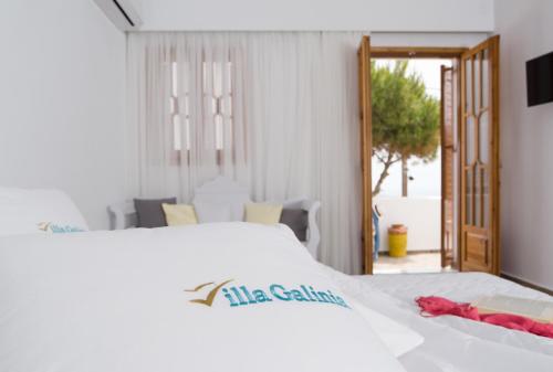 a bedroom with a white bed with a red towel on it at Villa Galinia in Akrotiri