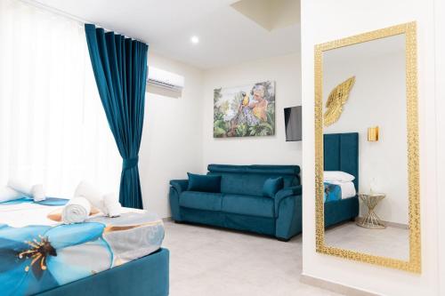 a living room with a blue couch and a mirror at Da Giuseppina in Ercolano