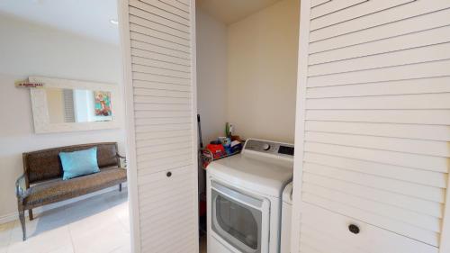a laundry room with a washer and dryer and a chair at ❤PiH❤MAJESTIC OCEANOcean Views Stunning Mauna Kea Resort Best Beaches Bikes in Hapuna Beach