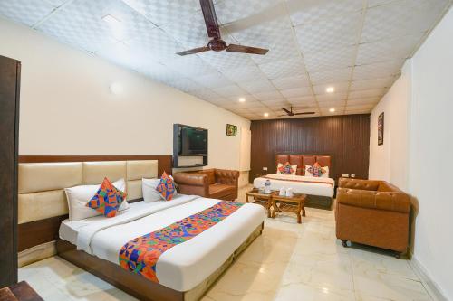 a bedroom with two beds and a flat screen tv at Via Lazeeno in Faridabad