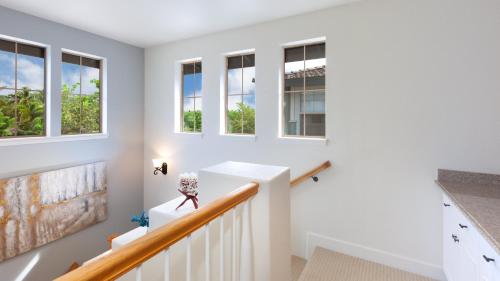 ワイコロアにあるTHE OASIS AT KULALANI Lovely 3BR Oasis in Kulalani Closest to Pool Complexの白壁・窓のある家の階段