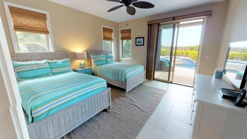 a bedroom with two beds and a balcony at HOUSE OF JOY Light and Airy 4BR KaMilo Home with Heated Pool and Spa in Waikoloa