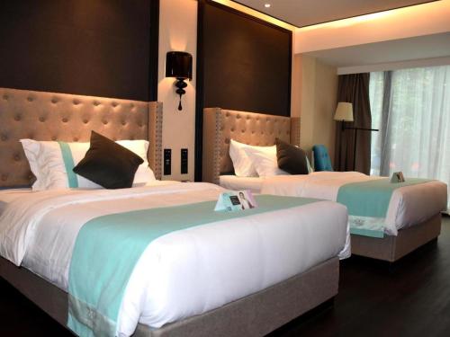 a hotel room with two beds in a room at Xana Hotelle Zhuhai Gongbei Port in Zhuhai