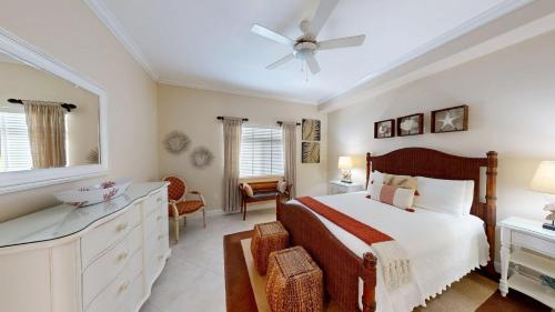 ein Schlafzimmer mit einem Bett, einer Kommode und einem Fenster in der Unterkunft South Bay Beach Club #11 - 4 Bedroom 4 Bathroom Unit in Dog City