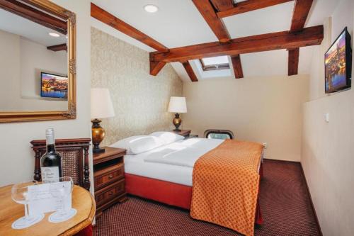 a bedroom with a bed and a table and a mirror at Wenceslas Square Hotel - Czech Leading Hotels in Prague