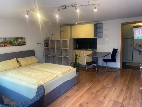 a bedroom with a bed and a kitchen and a table at Appartement Kellerhof im Zentrum von Murg in Murg