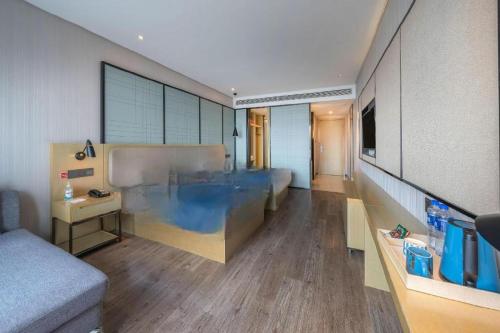 a large room with a bed and a couch at Echarm Hotel Taizhou International Convention and Exhibition Center 