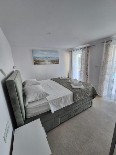 a white bedroom with a bed and a couch at Villa Rosea in Slatine
