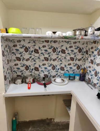 a kitchen counter with a pattern on the wall at Parvati Hotel and Stay in Manāli