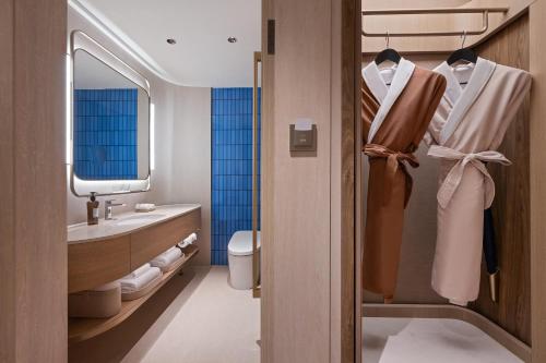 a bathroom with a toilet and a sink at Orange Crystal Qingdao May Fourth Square Olympic Sailing Center Hotel in Qingdao