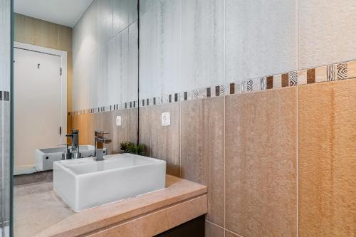 un bagno con un lavandino bianco e uno specchio di Casa Praia do Meco a Sesimbra