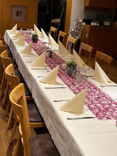 a long table with white tablecloths and napkins at Hotel-Restaurant Jägerhof in Reinsfeld