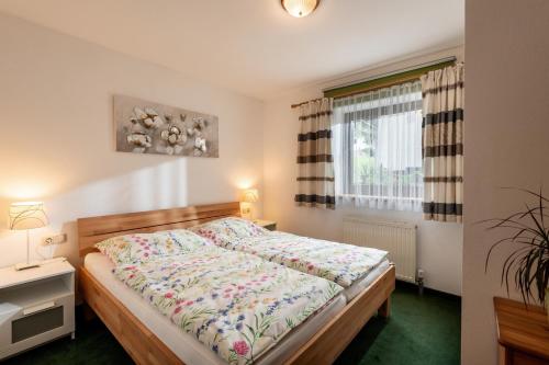 ein Schlafzimmer mit einem Bett und einem Fenster in der Unterkunft Haus Auebach in Ellmau