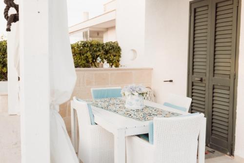 a white table with chairs and a vase on it at Tufara Villa a Mare in Polignano a Mare