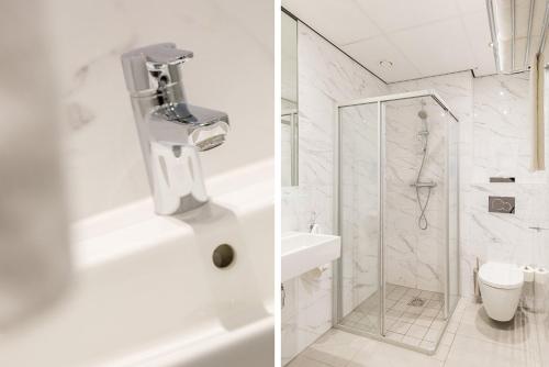 a white bathroom with a shower and a toilet at Hotel2Stay in Amsterdam