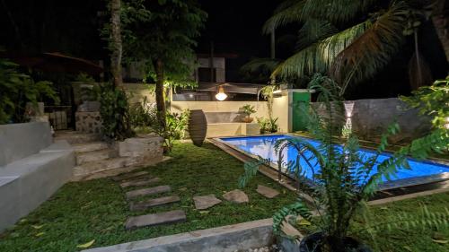 a backyard with a swimming pool at night at Soul Villas & Cabana Near Beach with Pool in Tangalle