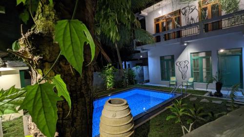 a house with a swimming pool next to a tree at Soul Villas & Cabana Near Beach with Pool in Tangalle