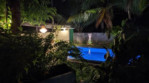 a swimming pool in a garden at night at Soul Villas & Cabana Near Beach with Pool in Tangalle