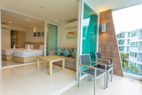 a hotel room with a bed and a table and chairs at C113 Beachfront Ocean Views Walk to beach pool in Ban Saiyuan (1)